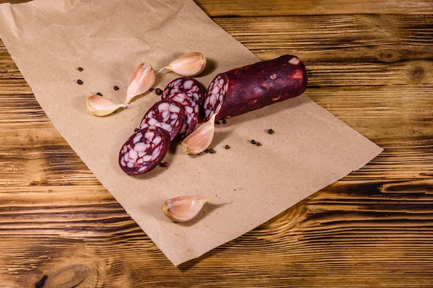 Sliced salami sausage and garlic on a brown wrapping paper