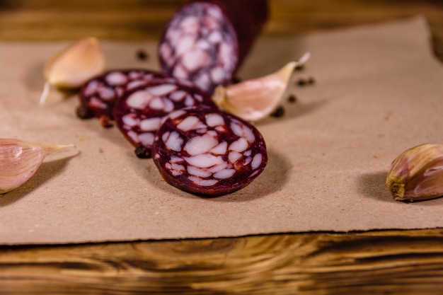 Sliced salami sausage and garlic on a brown wrapping paper