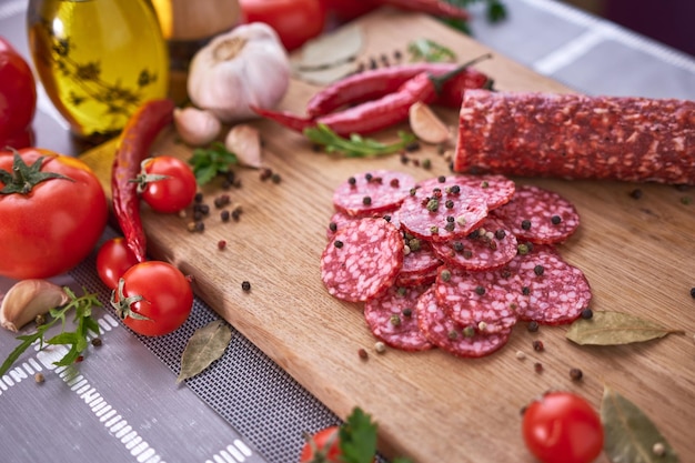 Sliced salami sausage on wooden cutting board at domestic kitchen