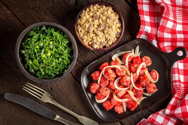 Sliced sausage with onion green cabbage and farofa