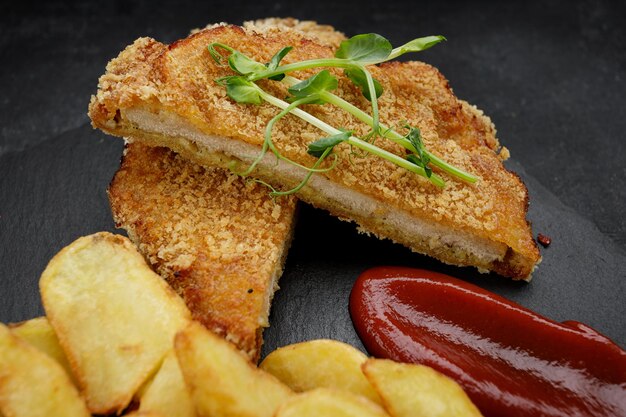 Sliced schnitzel with crispy fried potatoes and tangy ketchup