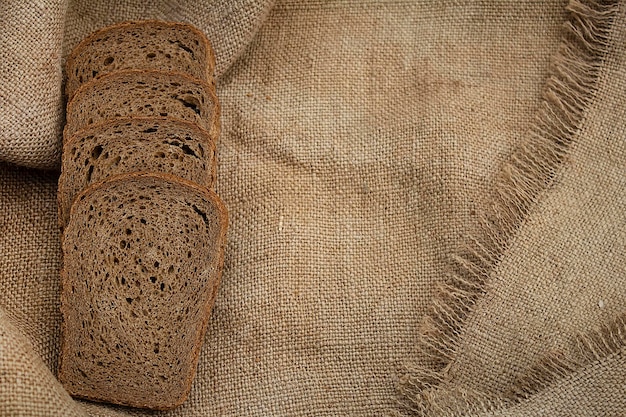 Sliced slices of rye bread lie on a linen tablecloth