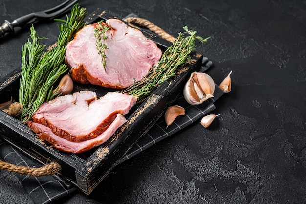 Sliced Smoked gammon pork shoulder meat with herbs Black background Top view Copy space