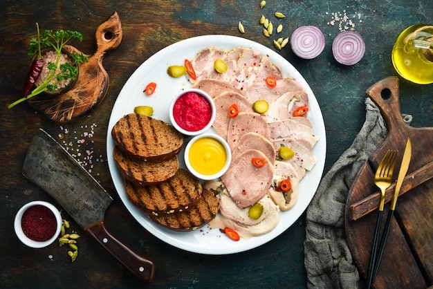 Sliced smoked meat and salami with sauce on a white plate Top view