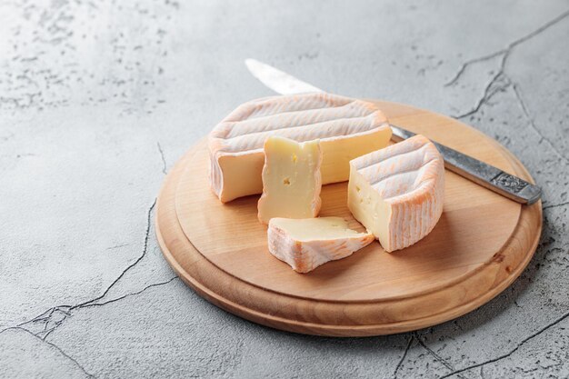 Sliced soft cheese with mold on a wooden board