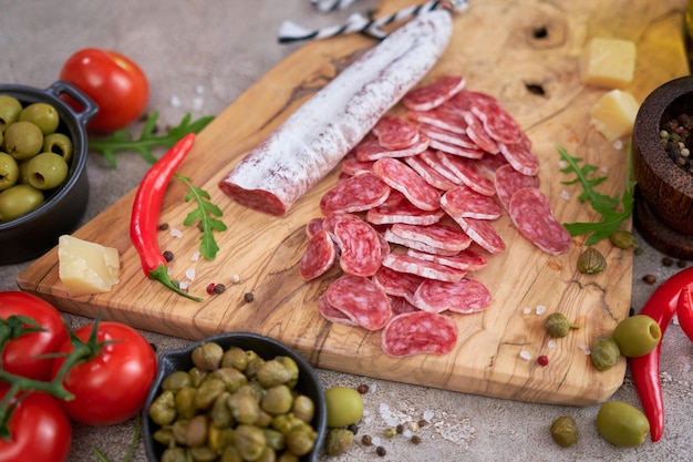 Sliced Spanish sausage fuet salami and vegetables on a domestic kitchen