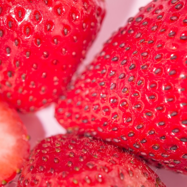 Sliced strawberry fruit isolated on pink background, pop art color concept