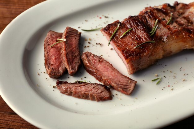 Sliced tasty steak on plate closeup