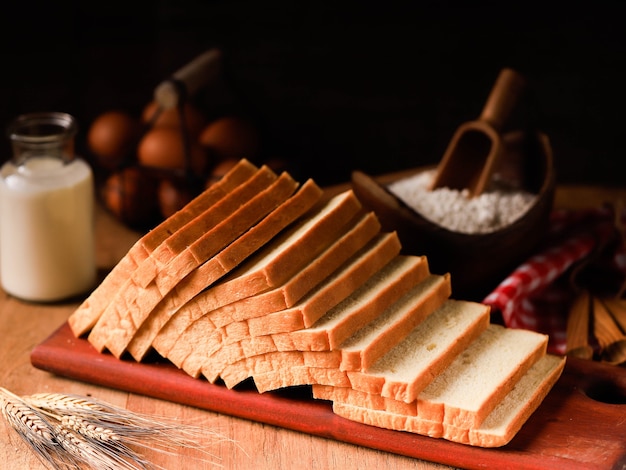 Sliced Toast Loaf White Bread (Shokupan or Roti Tawar) for Breakfast on Wooden Background, Served with Egg and Milk. Bakery Concept Picture