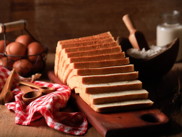 Sliced Toast Loaf White Bread (Shokupan or Roti Tawar) for Breakfast on Wooden Background, Served with Egg and Milk. Bakery Concept Picture