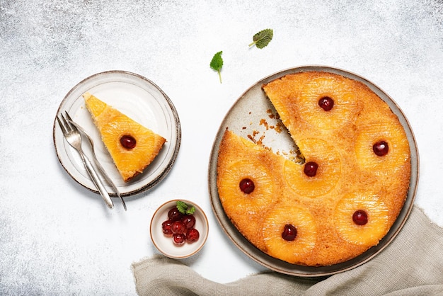 Sliced upside down pineapple cake with candied cherries and caramel