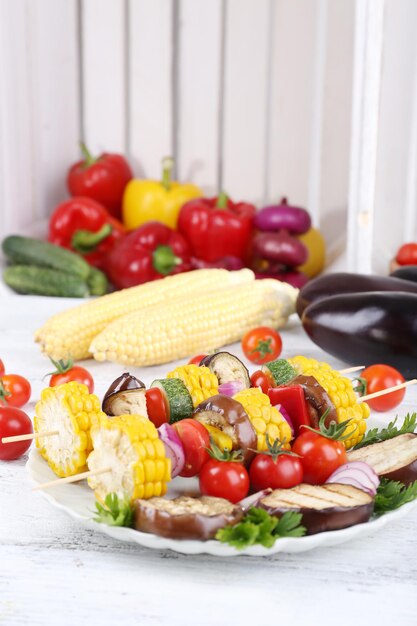 Sliced vegetables on picks on plate on table closeup