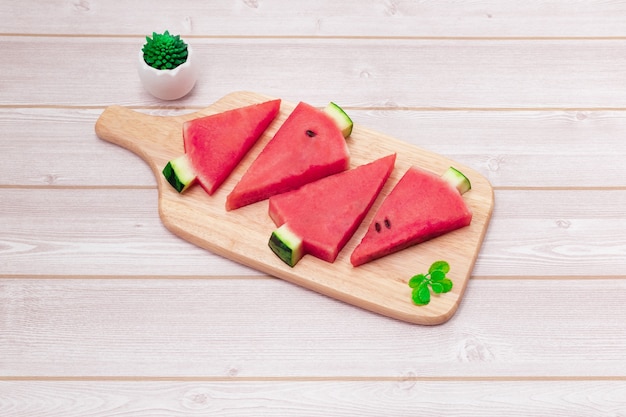 Sliced watermelon in a wooden bowl on the table