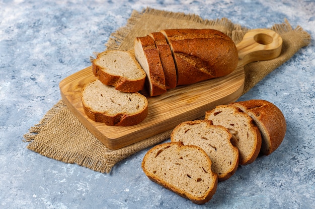 Sliced wholegrain bread on cutting board,top view