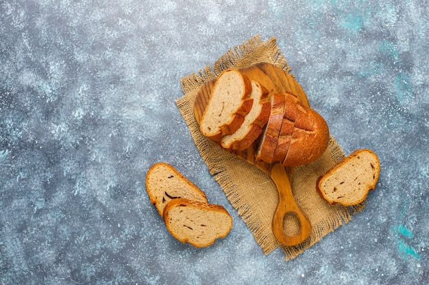 Sliced wholegrain bread on cutting board,top view