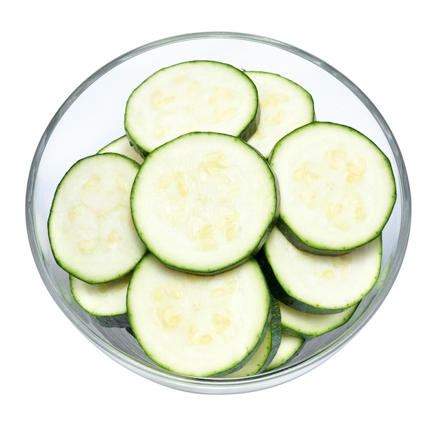 Sliced zucchini circles in glass bowl isolated on white background