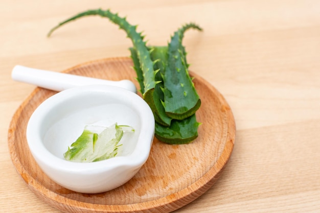 Slices of a aloe vera leaf and a ceramic mortar with transparent gel for medicinal purposes skin