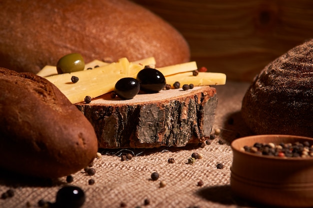 Slices of cheese on wooden desk between different breads. place for text