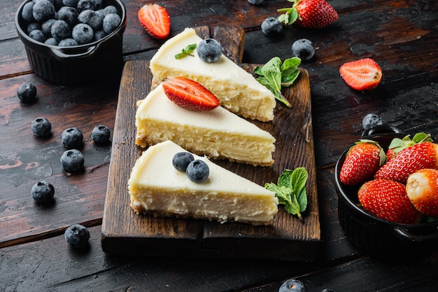 Slices Of Classical New York Cheesecake, on old dark  wooden table background