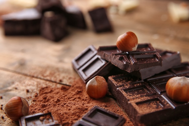 Slices of dark chocolate with nuts on table