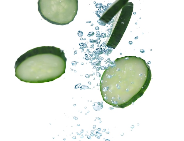 Slices of fresh cucumber under water on white background closeup Space for text