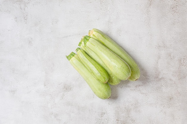 Slices of fresh vegetable marrow on light background