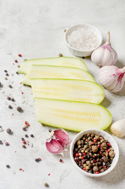 Slices of fresh vegetable marrow on light background