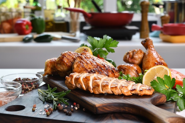 Slices of grilled chicken with ingredient on wooden cutting board in the kitchen