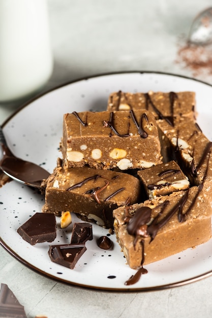 Slices of Halva with Peanut, wallnut and tea on a wooden surface.