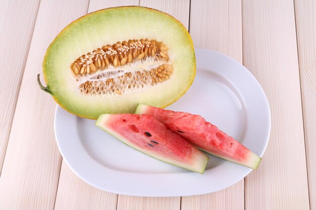 Slices of watermelon on plate on wooden background