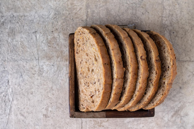 Slices of whole grain bread lie in a square wooden box copy space selective focus