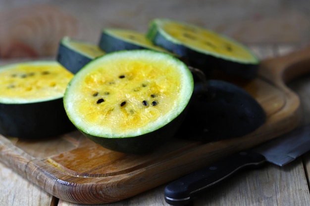 Slices of yellow watermelon on a wooden board.