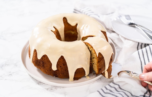 Slicing homemade eggnog bundt cake with an eggnog glaze