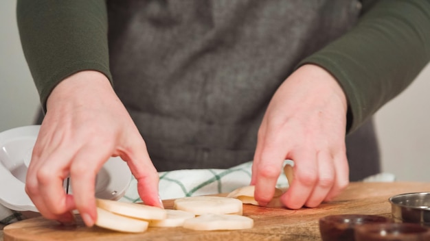 Slicing organic gold potatoes on a V-blade mandoline to prepare scalloped potatoes.