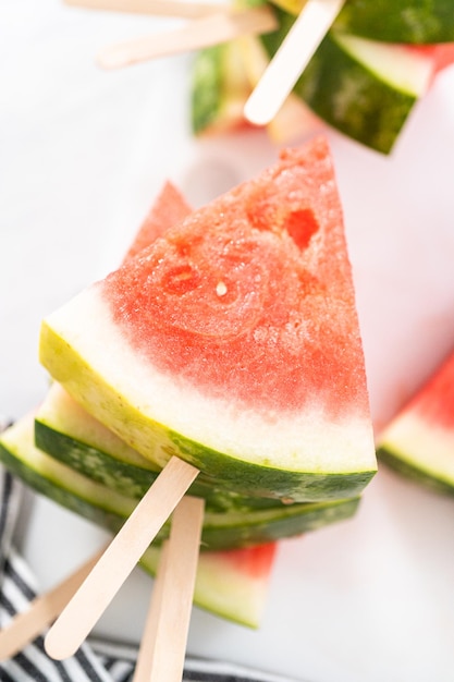 Slicing riped red watermelon to prepare chili lime watermelon pops.