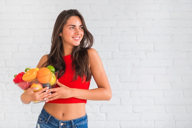 Slim attractive young woman holding healthy fruits and vegetables