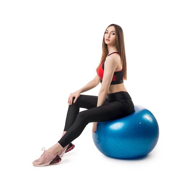 Slim fitness model in sportswear exercising with fitball