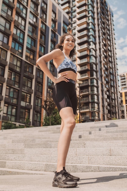 Slim girl in tight sportwear standing on the urban background