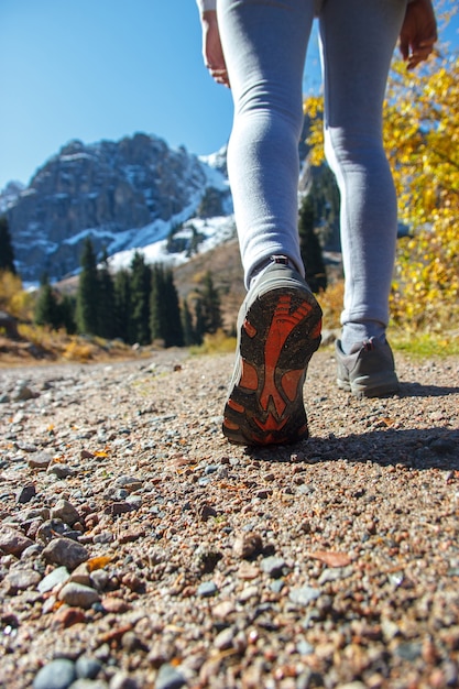 Slim legs on a mountain road. Training in sports shoes.