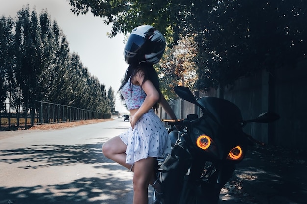 Slim sexy girl posing by motorcycle