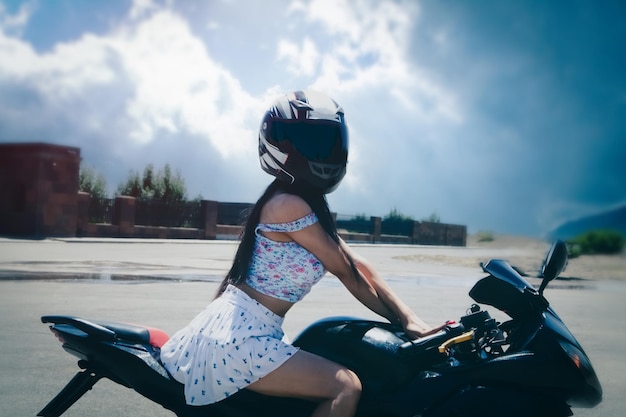 Slim sexy girl posing by motorcycle