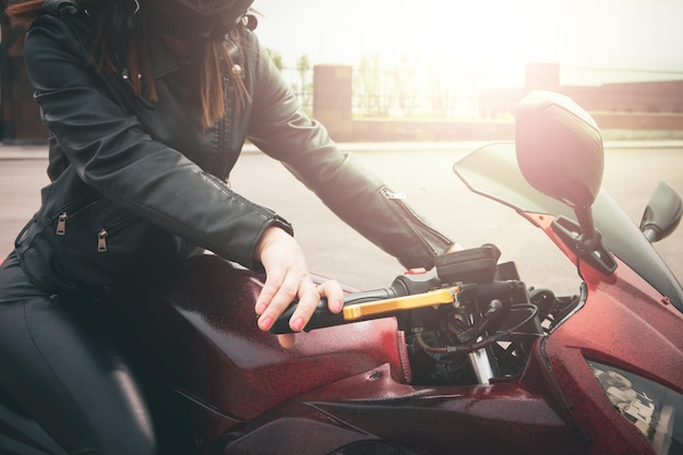 Slim sexy girl posing by motorcycle