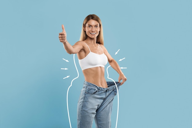 Slimming Result Happy Slim Female In Oversized Jeans Showing Thumb Up