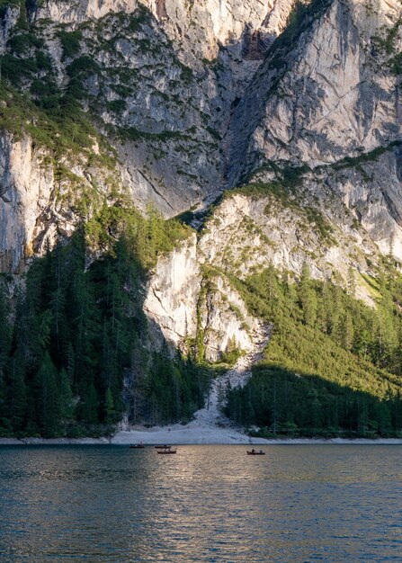 The slope of the mountain the beach near the mountain lake Braies Dolomites Alps Vacationers go boating A picturesque vacation spot for the whole family Vacation Travels Italy South Tyrol