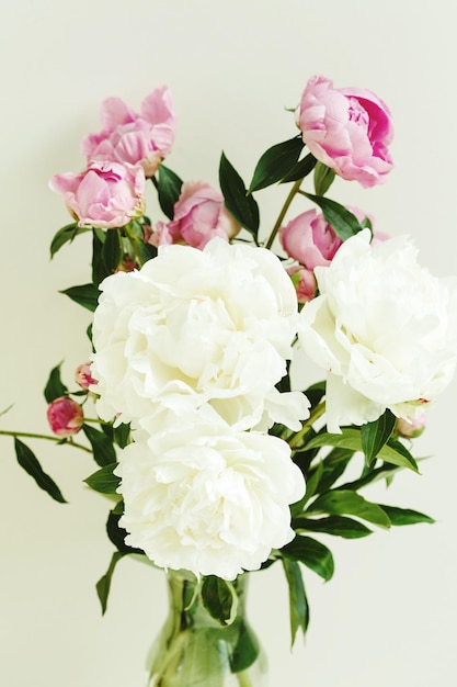 Sloppy flower bouquet of pink and white peonies flowers over pastel background spring and summer season flowers