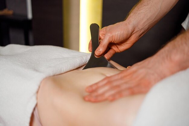 Sloseup view of the masseur's hands performing a abdominal massage