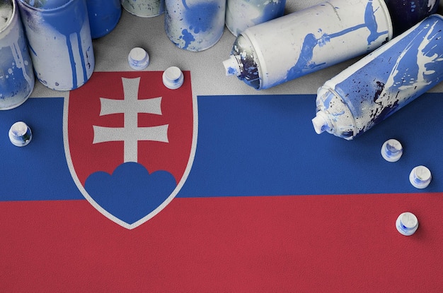 Slovakia flag and few used aerosol spray cans for graffiti painting street art culture concept