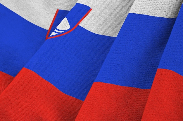 Slovenia flag with big folds waving close up under the studio light indoors The official symbols and colors in banner