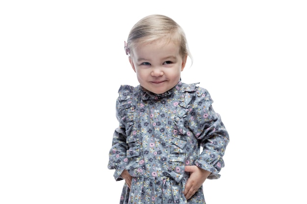 Sly smiling little girl in a dress Isolated on white background Vertical