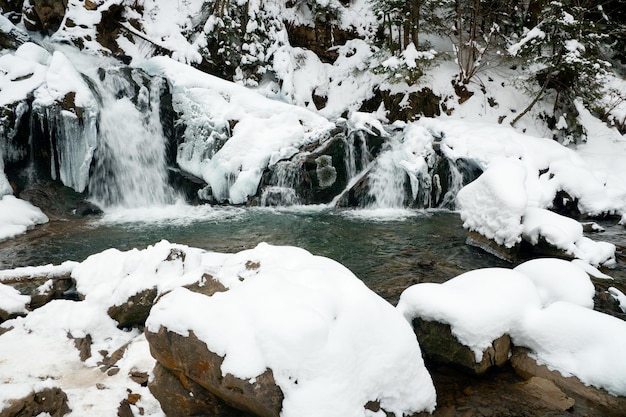 A small active waterfall Clean mountain stream snowy winter landscape wildlife background